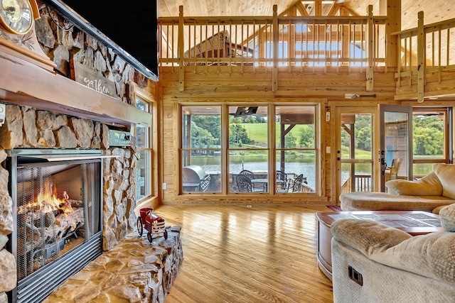 living room with a high ceiling, a fireplace, and hardwood / wood-style floors