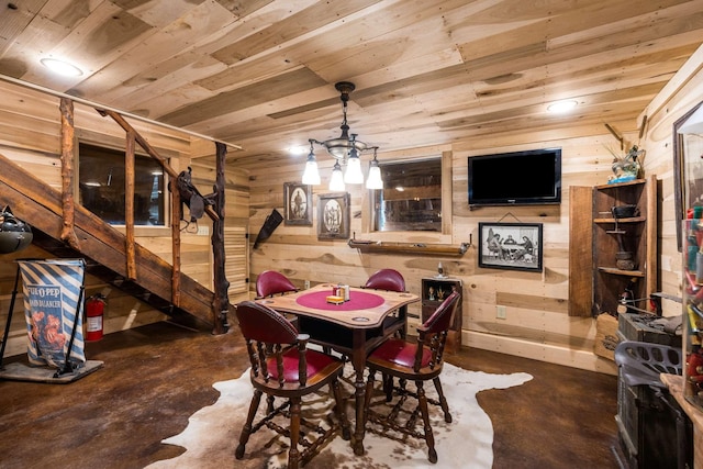 dining room with concrete floors, wood ceiling, and wood walls