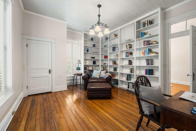 office space with an inviting chandelier, crown molding, built in shelves, and hardwood / wood-style floors