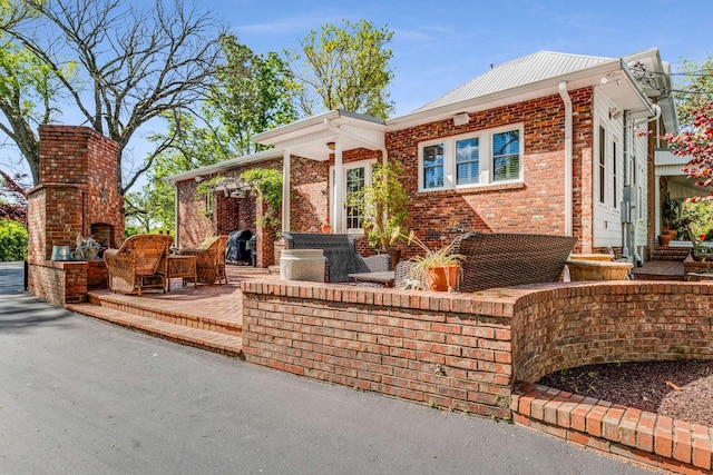 view of front of home with a patio and a fireplace