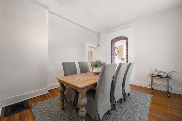 dining room with crown molding and dark hardwood / wood-style flooring