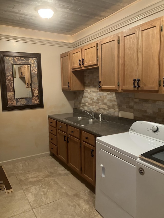 washroom featuring sink, cabinets, independent washer and dryer, crown molding, and light tile patterned floors