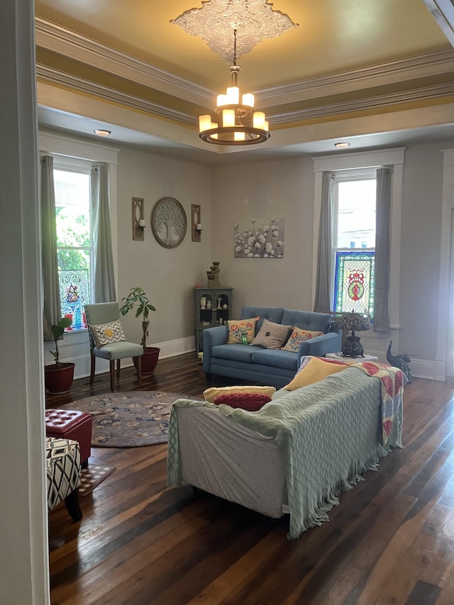 living room with ornamental molding, dark wood-type flooring, and a notable chandelier