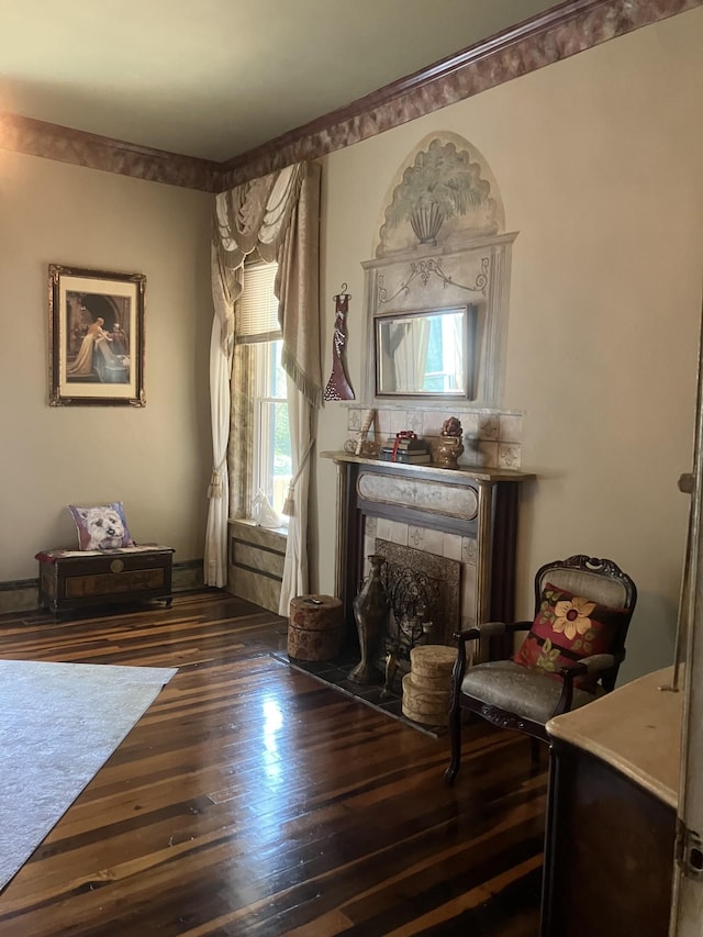 sitting room with dark wood-type flooring and a tiled fireplace