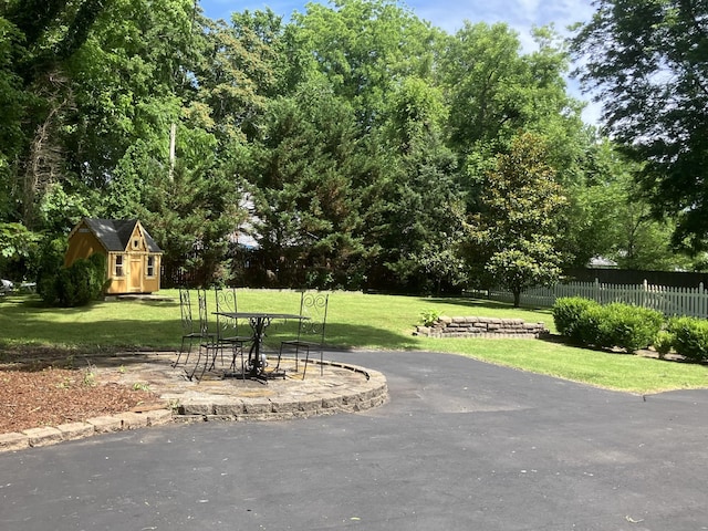 view of property's community with a lawn and an outdoor structure