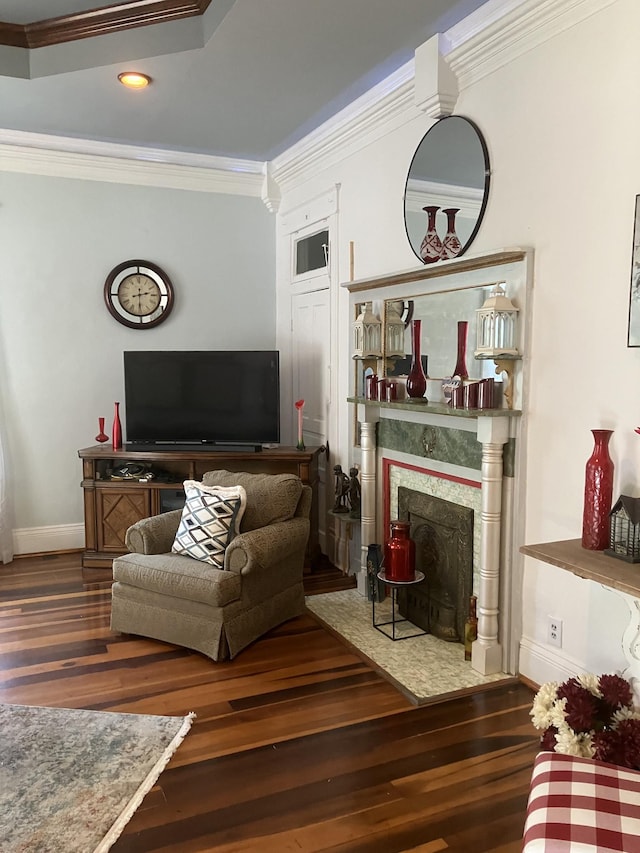 living room featuring dark hardwood / wood-style floors, ornamental molding, and a fireplace