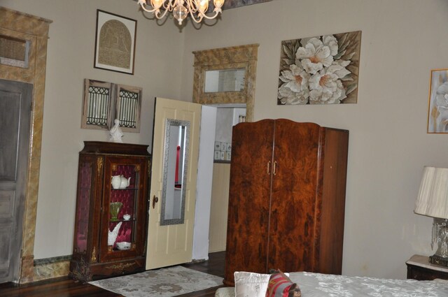 bedroom with dark hardwood / wood-style flooring and a chandelier