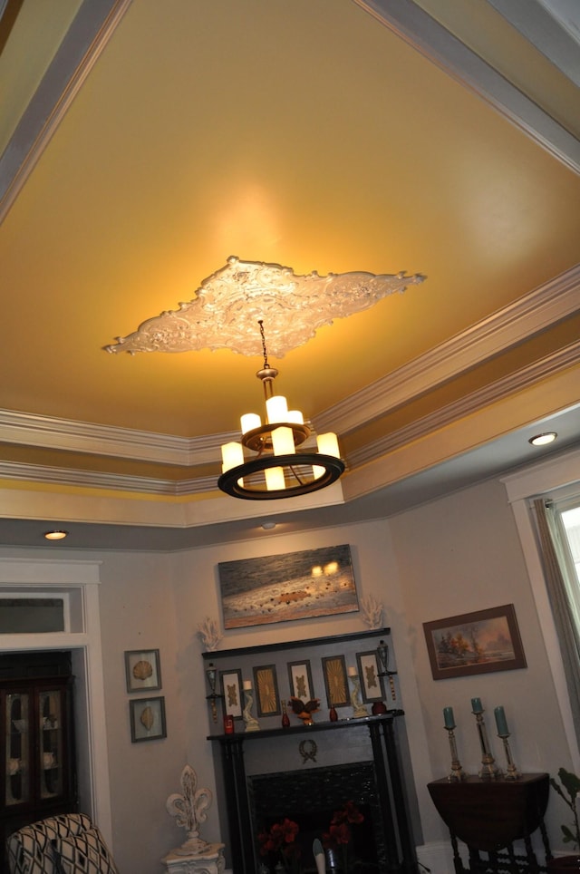 details with crown molding, a raised ceiling, and an inviting chandelier