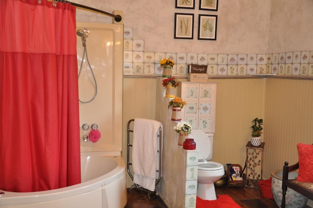 full bath with a wainscoted wall, wallpapered walls, toilet, and shower / tub combo with curtain