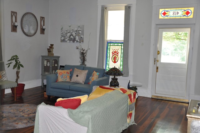 living area with baseboards, dark wood-type flooring, and a wealth of natural light