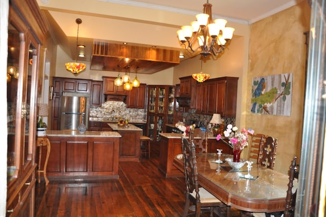 kitchen featuring hanging light fixtures, ornamental molding, freestanding refrigerator, and a center island