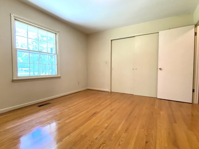 unfurnished bedroom with light hardwood / wood-style flooring and a closet