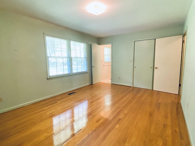 unfurnished bedroom featuring a closet and light hardwood / wood-style flooring