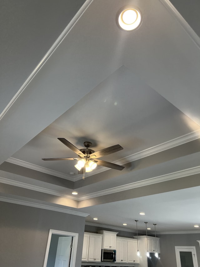 details with white cabinets, ceiling fan, and crown molding