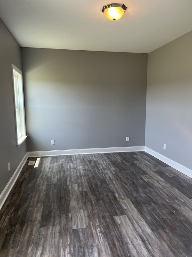 unfurnished room with dark hardwood / wood-style flooring