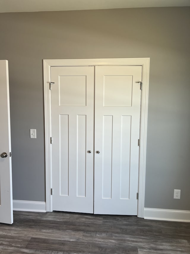 unfurnished bedroom featuring dark hardwood / wood-style floors and a closet