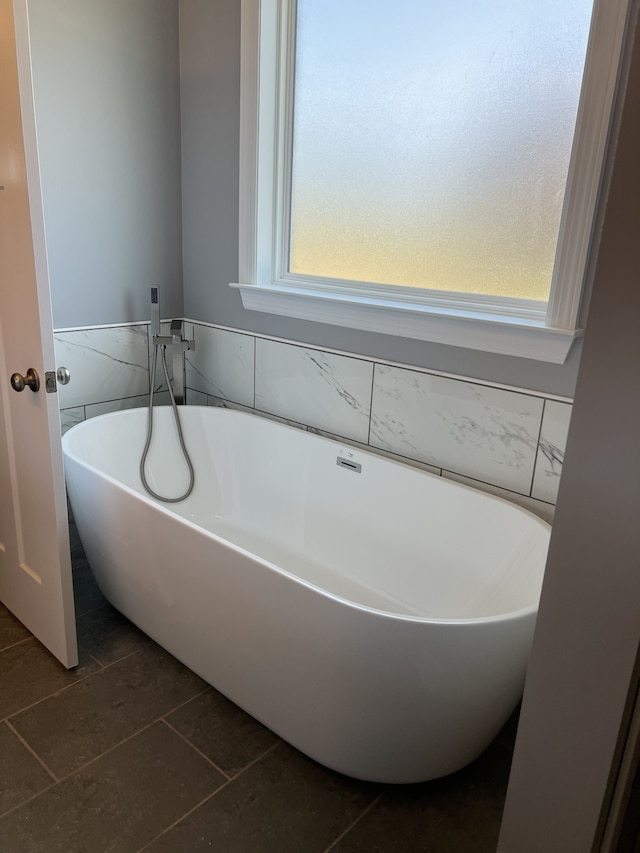 bathroom with a bath and tile patterned floors