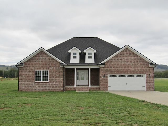 view of front of property with a garage, covered porch, and a front lawn