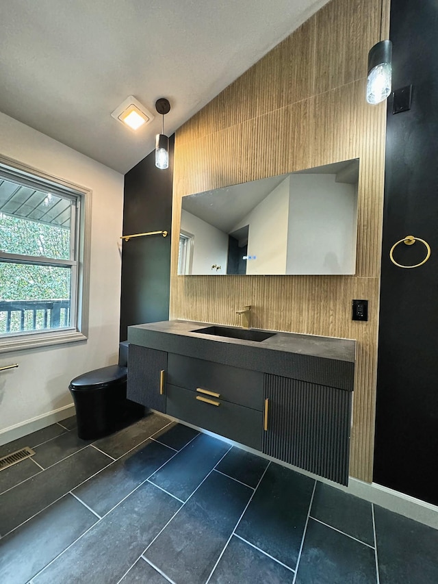 bathroom featuring visible vents, toilet, vaulted ceiling, vanity, and tile patterned flooring