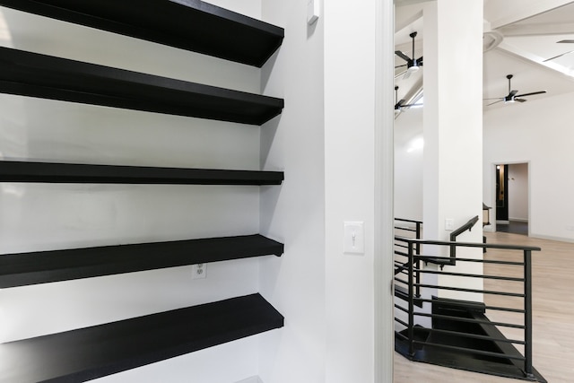 staircase with a high ceiling, wood finished floors, and a ceiling fan