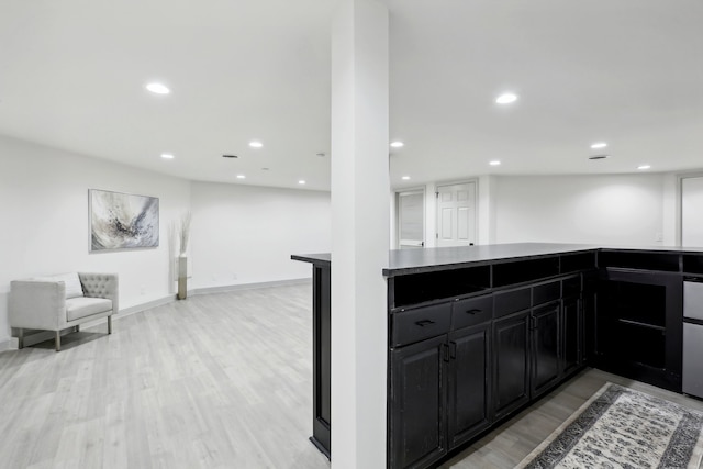 kitchen featuring light wood-type flooring, open floor plan, dark cabinets, and recessed lighting