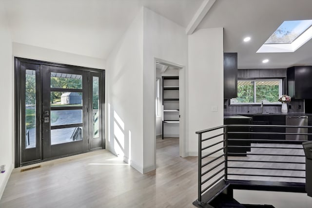 entrance foyer with recessed lighting, visible vents, light wood-style floors, lofted ceiling with skylight, and baseboards