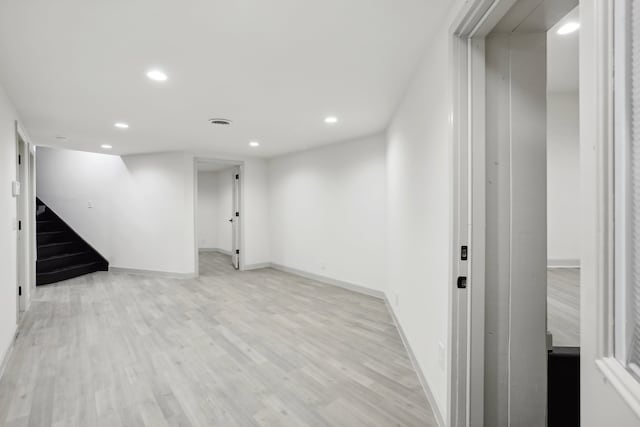 basement featuring recessed lighting, light wood-style flooring, baseboards, and stairs