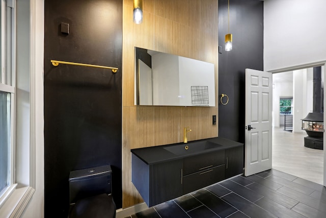 bathroom with vanity, a towering ceiling, and wood tiled floor