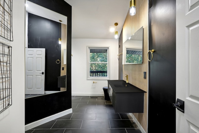 bathroom with tile patterned floors, a sink, and baseboards