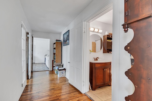 corridor with sink and light hardwood / wood-style floors