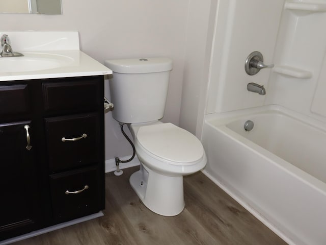 full bathroom featuring hardwood / wood-style flooring, vanity, shower / bathtub combination, and toilet