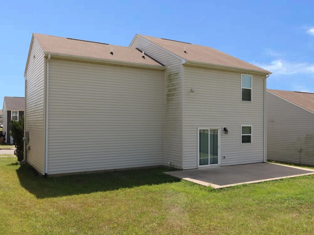 rear view of house featuring a patio area and a yard