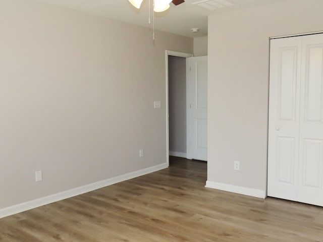 unfurnished bedroom featuring a closet, light hardwood / wood-style flooring, and ceiling fan