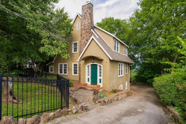 tudor-style house with a front lawn