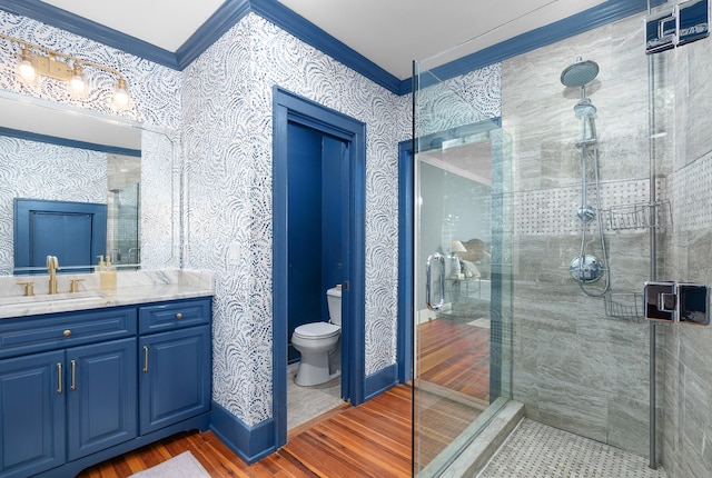 bathroom with walk in shower, ornamental molding, vanity, hardwood / wood-style floors, and toilet