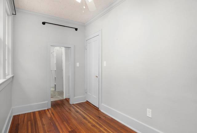 unfurnished bedroom featuring ceiling fan, crown molding, dark wood-type flooring, and a textured ceiling