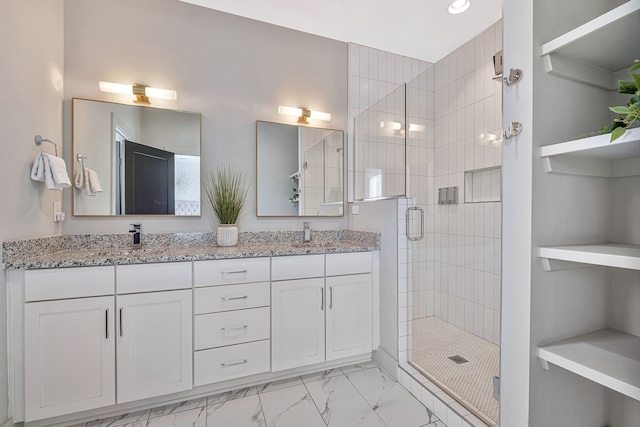 bathroom with tile floors, walk in shower, large vanity, and double sink