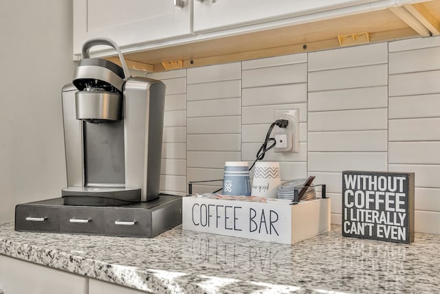 room details with white cabinetry and light stone counters