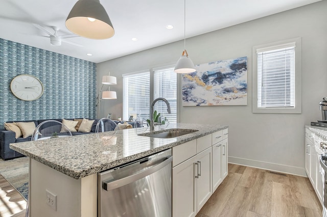 kitchen featuring light hardwood / wood-style floors, white cabinetry, an island with sink, sink, and dishwasher