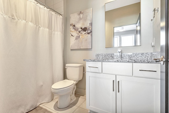 bathroom with tile floors, vanity, and toilet