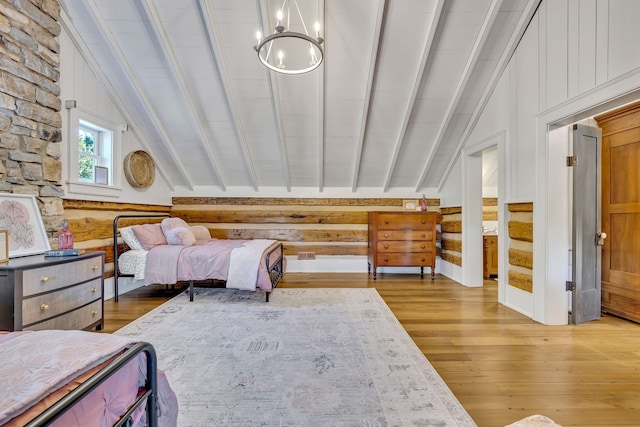 bedroom with a chandelier, hardwood / wood-style flooring, and lofted ceiling with beams