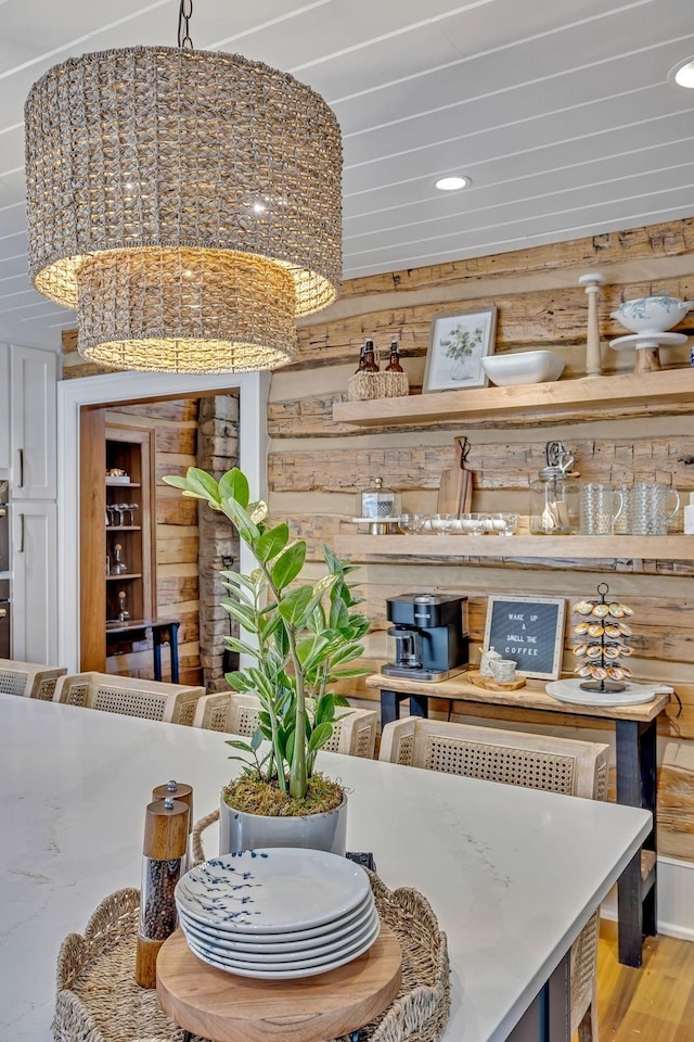 dining space with hardwood / wood-style flooring and wood walls