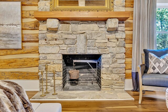 room details with a stone fireplace and wood-type flooring