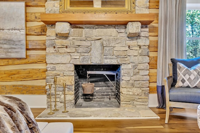 interior details with a stone fireplace and hardwood / wood-style flooring