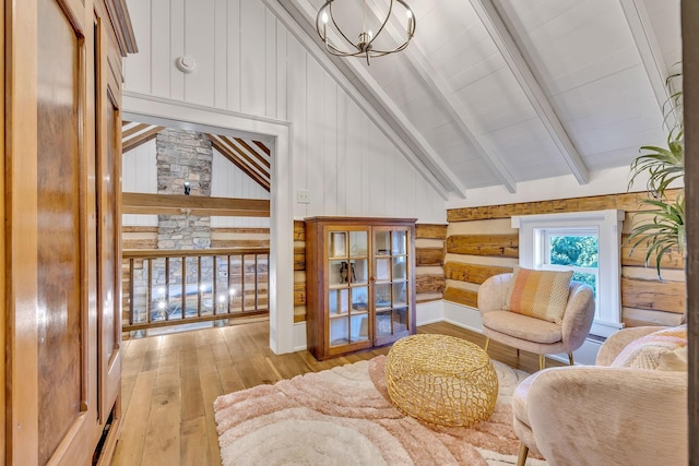 living room with vaulted ceiling with beams, a chandelier, and hardwood / wood-style flooring