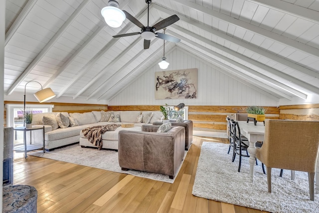 living room featuring lofted ceiling with beams and light hardwood / wood-style floors