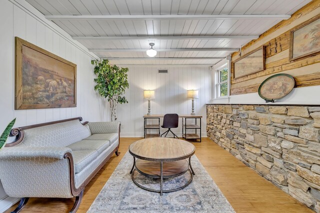 living room featuring beamed ceiling, hardwood / wood-style floors, and wooden ceiling