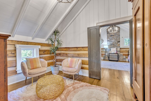 sitting room with vaulted ceiling with beams, light wood-type flooring, and ornate columns