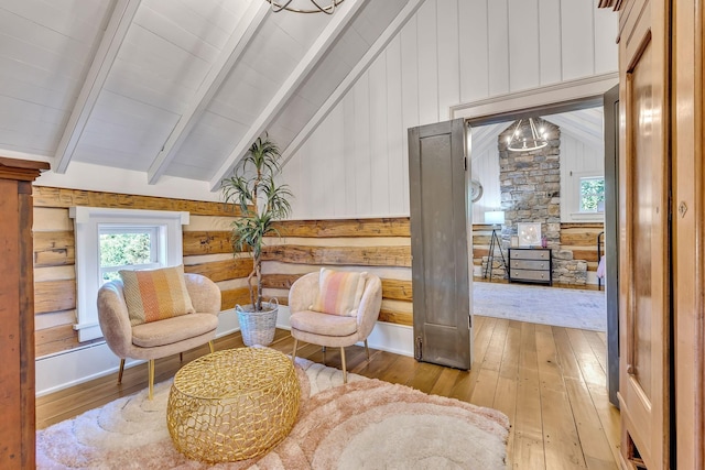 living area featuring lofted ceiling with beams and light wood-type flooring