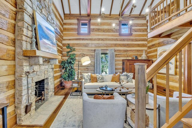 living room with a stone fireplace, beam ceiling, hardwood / wood-style floors, and high vaulted ceiling